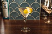 Una copa de martini con una rodaja de limón sobre una mesa. en Carnmore Hotel Christchurch, en Christchurch