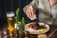 una persona está comiendo comida en una mesa con un plato de comida en Carnmore Hotel Christchurch, en Christchurch