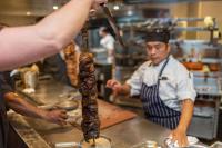 a man is preparing a piece of food in a kitchen at Pacific Hotel Cairns in Cairns