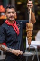 a man holding a skewer of meat on a stick at Pacific Hotel Cairns in Cairns