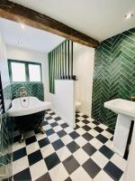 a bathroom with a black and white checkered floor at Le Victor Hugo in Rouen