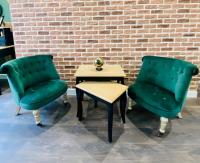 two green chairs and a table and a brick wall at Le Victor Hugo in Rouen