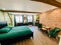 a bedroom with a green bed and a brick wall at Le Victor Hugo in Rouen