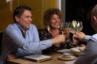 een man en een vrouw zitten aan een tafel met wijnglazen bij Vakantiepark de Molenhoek in Kamperland