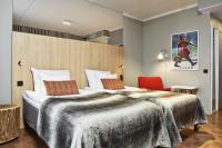 a hotel room with a large bed and a red chair at Original Sokos Hotel Vaakuna Rovaniemi in Rovaniemi