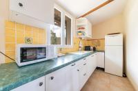 a kitchen with white cabinets and a white refrigerator at Les Lavandes - Charmante maison avec terrasse in Pertuis