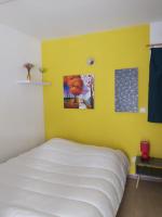 a bedroom with a white bed and a yellow wall at Luz St Sauveur, Appartement 3 personnes, vue montagne, exposé sud, Résidence très calme in Luz-Saint-Sauveur