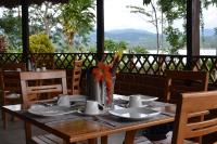 Una mesa de madera con platos y tazas y flores encima. en Las Jawas Lodge, en Sauce