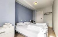 a bedroom with a white bed and a blue wall at Nice Apartment In Bredene With Kitchen in Bredene