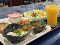 bandeja con un plato de comida y un vaso de zumo de naranja en Sky Heart Hotel Shimonoseki, en Shimonoseki