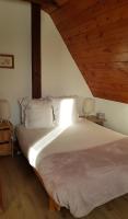 a bedroom with a white bed with a wooden ceiling at Studio Marie-Rose in Ribeauvillé