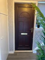 Una puerta de madera en un pasillo con una planta. en Culbin Lodge, en Glasgow