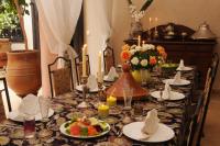 ein langer Tisch mit Tellern mit Essen und Kerzen in der Unterkunft Riad Saba in Marrakesch