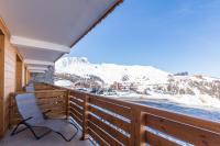 a balcony with a chair and snow covered mountains at Le Vancouver in La Plagne