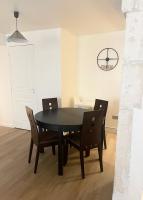 a dining room with a black table and chairs at Charmant logement rénové dans l’hyper centre in Auxerre