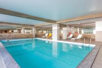 a swimming pool with blue water in a building at Le Vancouver in La Plagne