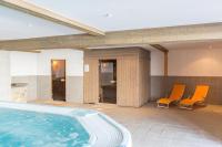a swimming pool with orange chairs in a building at Le Vancouver in La Plagne