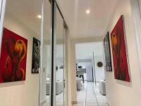 a hallway with paintings on the walls of a living room at YOU WELCOME VILLA in Case-Pilote