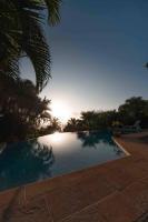 a swimming pool with the sun setting in the background at YOU WELCOME VILLA in Case-Pilote