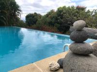 a stack of stones sitting next to a swimming pool at YOU WELCOME VILLA in Case-Pilote