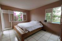 a bedroom with a bed and two windows at YOU WELCOME VILLA in Case-Pilote
