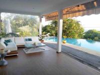 a living room with a white couch and a pool at YOU WELCOME VILLA in Case-Pilote