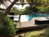 a patio with a table and chairs next to a pool at YOU WELCOME VILLA in Case-Pilote