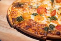 a pizza sitting on top of a wooden table at C-One Resort Jaeundo in Sinan