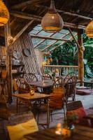 un restaurante con mesas y sillas de madera y un balcón en Yay Sustainable, en Guachaca