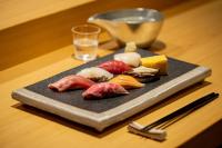 a plate of food with meat and cheese on a table at Tanuki Nozawa in Nozawa Onsen
