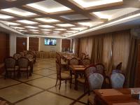 Un comedor con mesas y sillas y un televisor. en Vakkom Palazzo, en Varkala