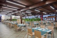 un restaurant avec des tables et des chaises bleues dans un bâtiment dans l'établissement Granada Luxury Okurcalar, à Okurcalar