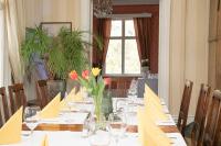 a dining room with a table with flowers on it at Landhaus Kekkola in Mikkeli