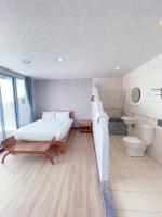 a bedroom with a large bed and a bathroom at Blue Sea Inn in Eluan