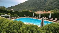 a swimming pool with chairs and umbrellas at Chalet Balkan in Valevtsi