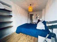 Un dormitorio con una cama azul y una cámara en Appartement Petit Messier, en Senones