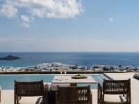 Una mesa con copas de vino y vista al océano. en Ezio Bo Luxury Living, en Mykonos ciudad