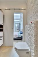 a white bathroom with a toilet and a bedroom at Cosy appartement Kur 62 Hasselt in Hasselt