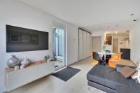a living room with a couch and a tv on a wall at Cosy appartement Kur 62 Hasselt in Hasselt