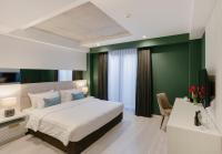 a bedroom with a white bed and a green wall at Original Boutique Hotel in Tbilisi City
