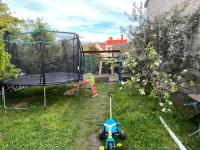 a toy bike in the grass next to a trampoline at 2Appartement dans un pavillon ac vue sur le jardin in Argenteuil