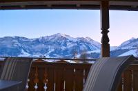 a balcony with two chairs and a view of mountains at Apartment Igor - by Alpen Apartments in Piesendorf