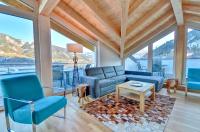 a living room with blue furniture and large windows at Apartment Snowmountain - by Alpen Apartments in Zell am See