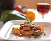 モーディカにあるAgriturismo Il Granaio Hotel & SPAの肉と野菜が乗った白い皿とグラスワイン