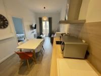 eine Küche und ein Wohnzimmer mit einem Tisch und einer Theke in der Unterkunft Cosy T3 proche Gare et Polygone in Béziers