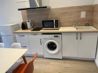eine Küche mit einer Waschmaschine und einer Mikrowelle in der Unterkunft Cosy T3 proche Gare et Polygone in Béziers