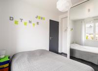 a white bedroom with a bed and a mirror at L escale bretonne- séjour chez l habitant in Mordelles