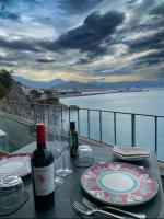 uma mesa com uma garrafa de vinho e copos numa varanda em Hotel La Lucertola em Vietri
