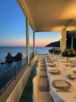 uma fila de mesas numa varanda com o oceano em Hotel La Lucertola em Vietri