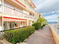a building with a sidewalk next to the ocean at Apartment Le Grand Large-1 by Interhome in Sainte-Maxime